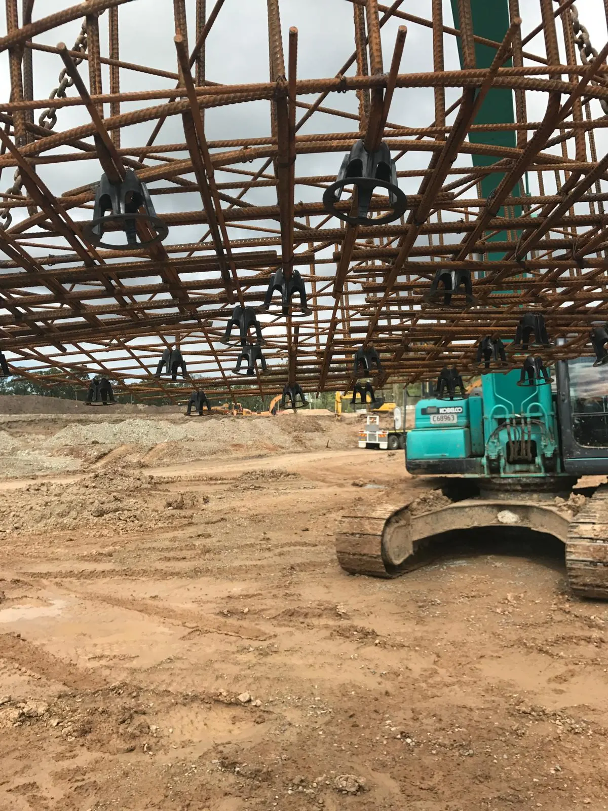 Reinforcement cage on chairs with an excavator underneath
